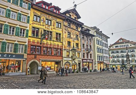 LUCERNE SWITZERLAND - JANUARY 04 2015: Weinmarkt fountain and medieval buildings beautifully decorated with frescos at picturesque square Muhlenplatz in Lucerne Switzerland