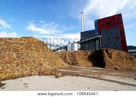 Bio Power Plant With Storage Of Wooden Fuel Against Blue Sky