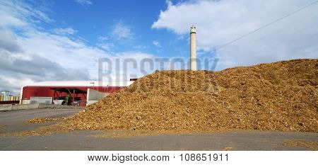 Bio Power Plant With Storage Of Wooden Fuel Against Blue Sky