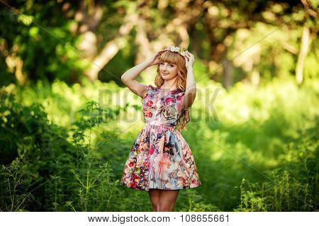 Beautiful young woman in fashionable clothes in the summer garden