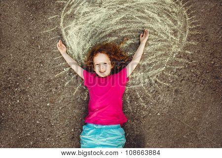 Curly Girl Lying On Asphalt With Painted Yellow Sun.