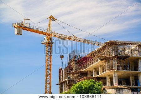 Yellow crane in Construction Site on blue sky.