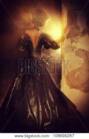 Art Fashion. Beautiful young woman in elegant historical dress and with barocco updo hairstyle posing in the ruins of the castle. Renaissance. Barocco.