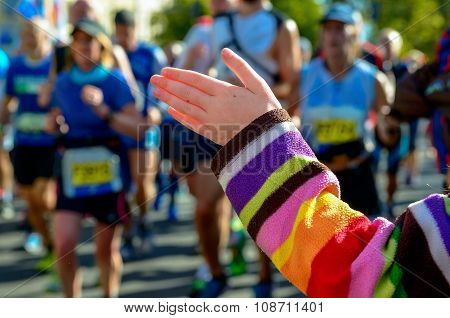 Marathon running race, support runners on road, child's hand giving highfive, sport concept