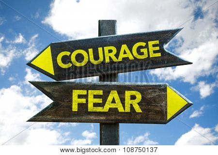 Courage - Fear signpost with sky background