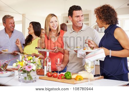 Group Of Mature Friends Enjoying Buffet At Dinner Party