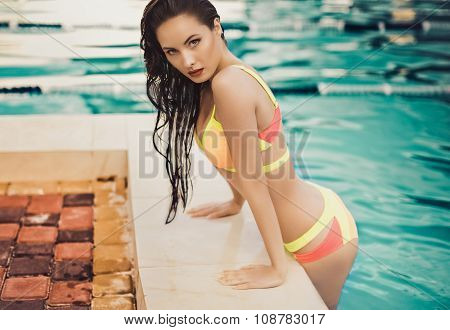 beautiful long hair female model posing by the pool