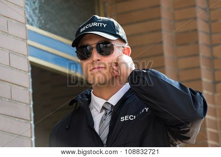 Young Security Guard Standing In Front Of The Entrance