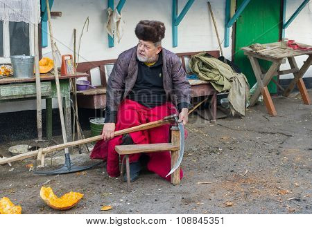 Ukrainian peasant getting ready to whet a scythe