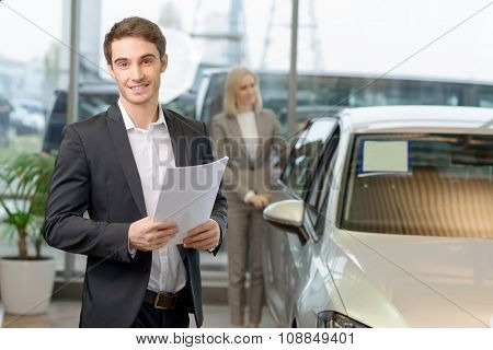 Salesman is holding papers for his client.