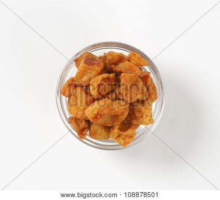 bowl of salty pork greaves on white background