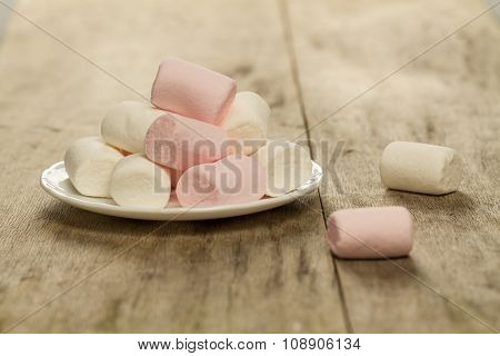 Sweet Marshmallows On White Plate On Wooden Background