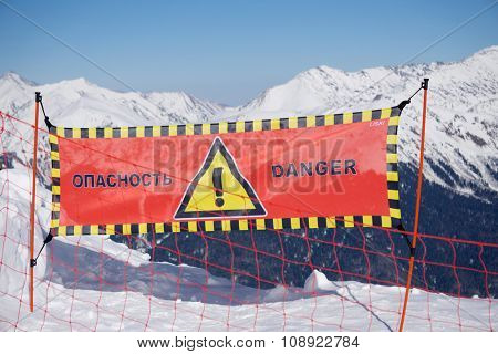 Avalanche danger sign in snow, winter mountain ski resort