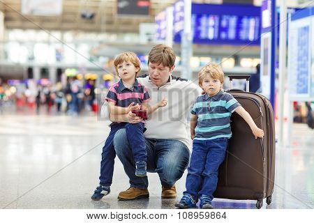 Father and two little sibling boys at the airport