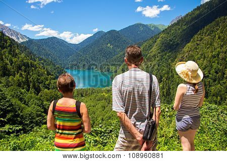 Tourists looking at mountain lake Rizza