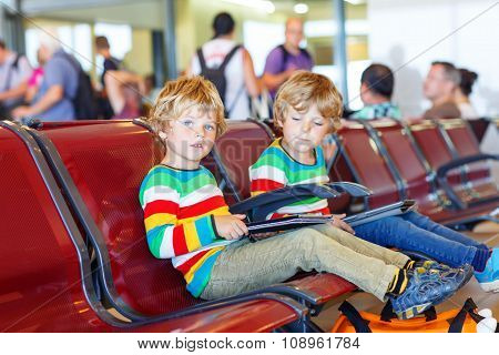 Two tired little sibling boys at the airport