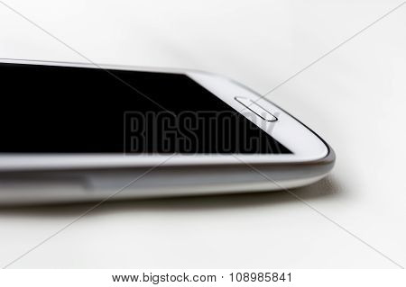 A White Handy With Blank Display Lying On White Leather