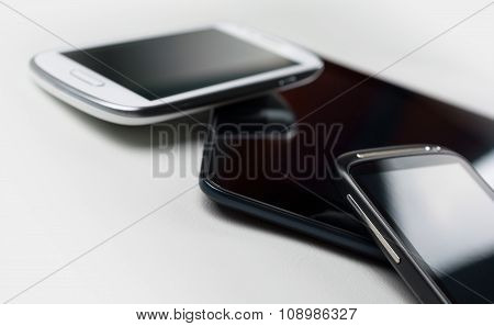 A White And A Black Mobile Leaning On A Tablet