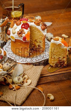 Traditional Easter cake with decorations and cupcakes on wooden table