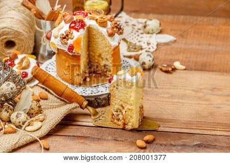 Traditional Easter cake with decorations and cupcakes on wooden table