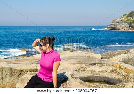 Asian girl explores the coastline of Bondi Beach in SydneyAustralia.