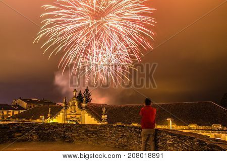 Guy watching fireworks in the local festival of San Froilan in Lugo. Spain.