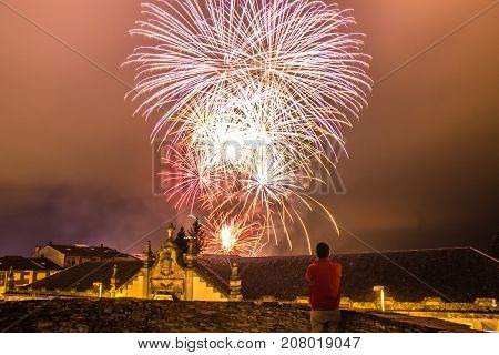 Guy watching fireworks in the local festival of San Froilan in Lugo. Spain.