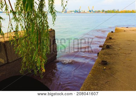 The riverscape of large drainage steel pipe background. concept of industrial wastes and environmental pollution