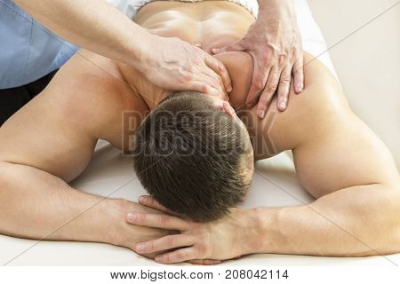 The process of sports massage is done by a man in a massage salon