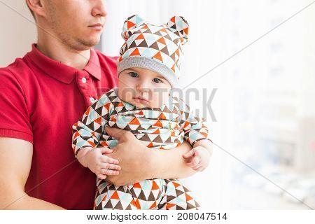 Adorable Caucasian baby and his father. Portrait of a three months old baby boy.