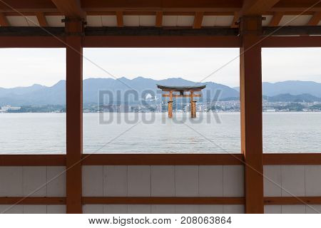 The Floating Torii gate framed by pillars and walls of Itsukushima shrine in Miyajima, Japan.