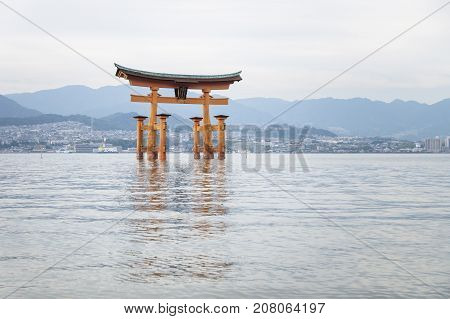 The Floating Torii gate in front of blue mountainrange in Miyajima, Japan.