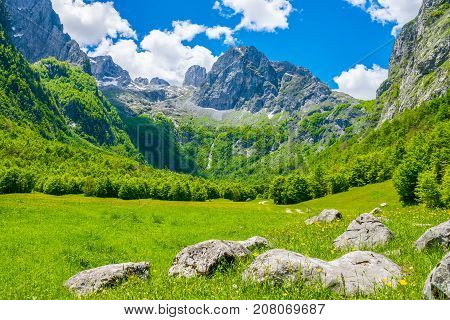 A Dirt Road Through A Picturesque Plain Among The High Mountains.
