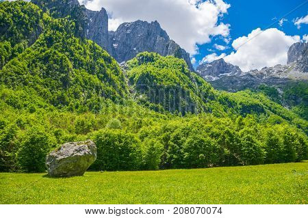 A Dirt Road Through A Picturesque Plain Among The High Mountains.
