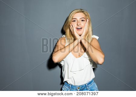 Shocked Girl Covers Her Mouth With Hands, Isolated On Gray