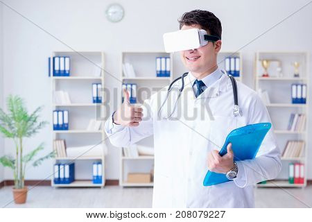 Young doctor with vr virtual reality headset working in the offi