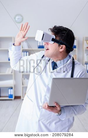 Young doctor with vr virtual reality headset working in the offi