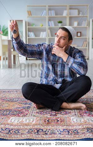 Young muslim man praying at home