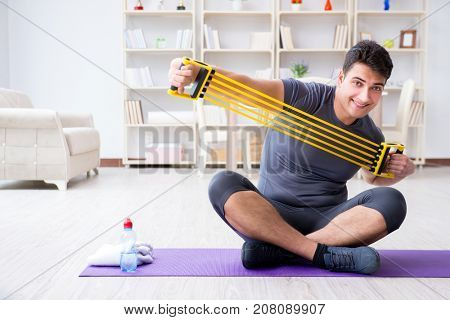 Young man exercising at home in sports and healthy lifestyle con