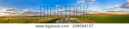 beautiful rural autumn landscape panorama with road field and blue sky with white clouds. panoramic autumn view. sunset over agricultural fields and path