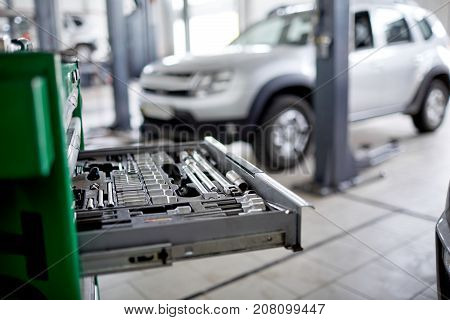 Extended green box with tools in focus on the blurred car background