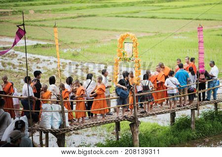 LAMPANG THAILAND - JULY 9 2017: Unidentified people offer food to monks in Devo tradition on JULY 9 2017 in Lampang Thailand. Tak Bat Devo is the tradition in end of Buddhist Lent.