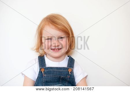 Smiling red-haired girl with freckles and caries