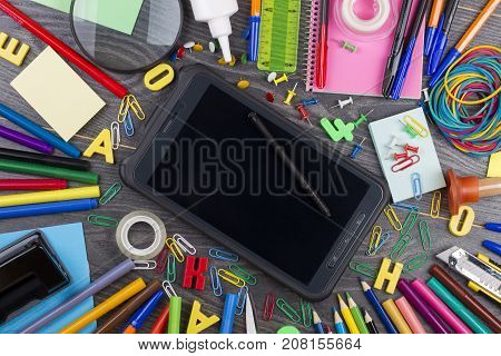 Back to school. Set of school objects for modern education: pens scissors pensils and other multicolored accessories on wooden desk. Top view