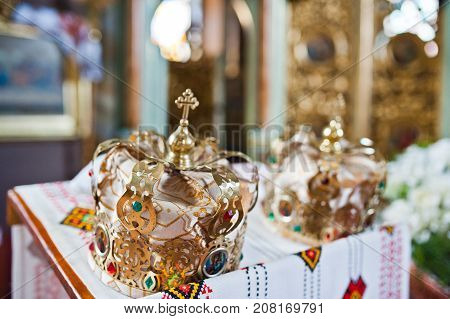 Close-up Photo Of Wedding Crowns In The Church On The Table.
