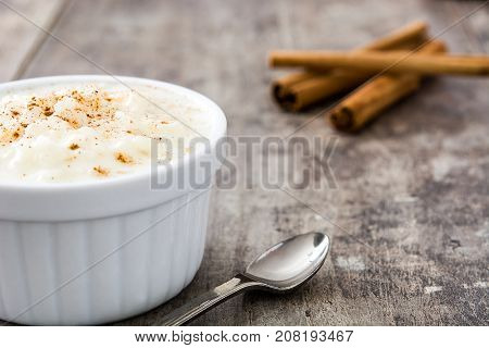 Arroz con leche. Rice pudding with cinnamon on wooden background