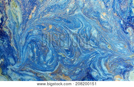 Marbled blue abstract background with golden sequins. Liquid marble ink pattern