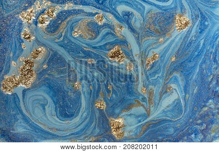 Marbled blue abstract background with golden sequins. Liquid marble ink pattern
