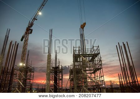 ndustrial machinery and the construction crane. Cranes and skyscraper under construction, city skyline at sunset, sunrise Building under Construction site