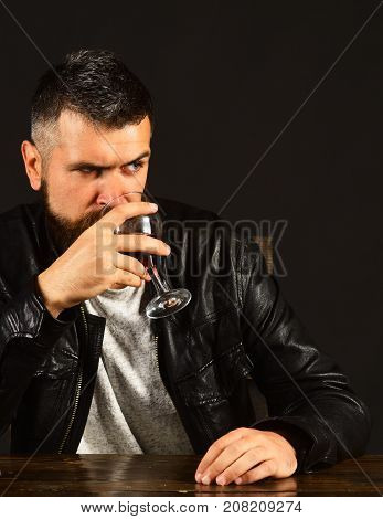 Man With Beard Holds Glass Of Wine On Brown Background